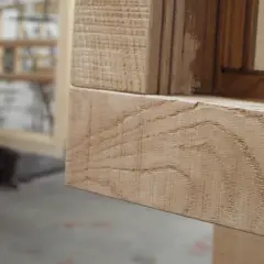 Marco de ventana de madera con vetas visibles y detalle de textura.