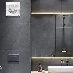 Extractor de baño blanco instalado en pared de azulejos grises.