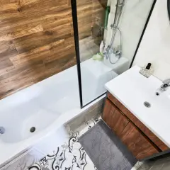 Baño moderno con ducha y bañera. Aprende como quitar una mampara pegada con silicona para renovar tu espacio.