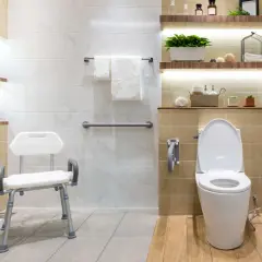Baño moderno con duchas adaptadas para personas mayores, asiento de ducha, barras de apoyo y un inodoro.
