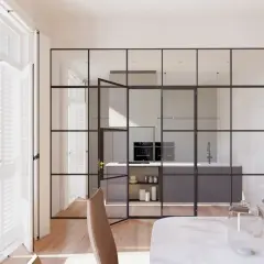 Elegantes tipos de cerramientos interiores de cristal y metal separan la cocina moderna del comedor.