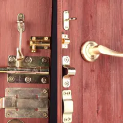 Detalle de varios tipos de pestillos para puertas de madera, con acabados dorados y plateados, incluyendo manijas.
