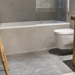 Baño moderno con bañera, inodoro suspendido y lavabo de madera. Averigua cuanto cuesta poner una bañera.