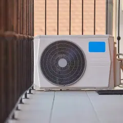 Unidad exterior de aire acondicionado instalada en un balcón.