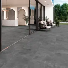 Amplia terraza con moderno suelo para terraza de gres porcelánico gris. Muebles de exterior y entrada acristalada.
