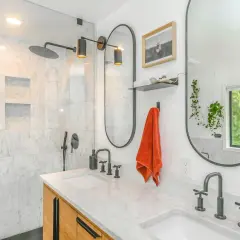Baño moderno con ducha empotrada, lavabos dobles y grifería negra. Ideal para instalar grifo ducha empotrado.