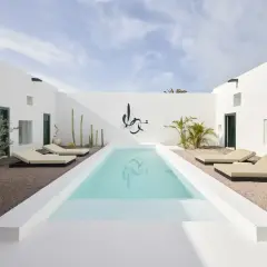 Patio minimalista con piscina, tumbonas y cactus. Ideas para decorar un patio con piscina y crear un oasis moderno.