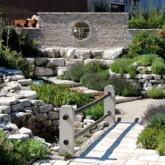 Un hermoso jardín con cascadas de piedra y plantas aromáticas, ideal para decorar jardín con piedras y crear un oasis de paz.