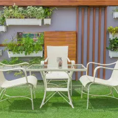 Un oasis verde en patios pequeños con césped artificial. Muebles blancos y plantas colgantes crean un rincón acogedor.
