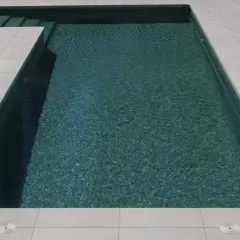 Bordes de piscinas modernas con escalones integrados y un revestimiento de baldosas claras que contrastan con el agua turquesa.