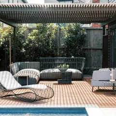 Modernos porches para patios con muebles de exterior, piscina y vegetación exuberante.