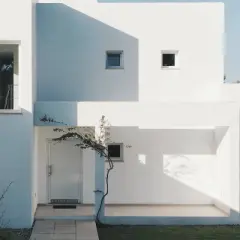 Fachada blanca moderna con sombras marcadas. La mejor pintura para fachadas exteriores protege y embellece esta arquitectura minimalista.