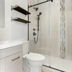 Baño moderno con lavabo, inodoro y plato de ducha de resina. Ideal para aprender como reparar un plato de ducha de resina.