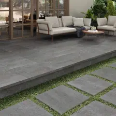 Terraza moderna con suelo de baldosas grises, ideal para pintar suelo terraza exterior. Muebles de exterior y plantas crean un oasis.