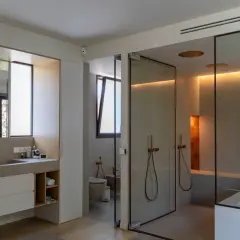 Baño moderno con ducha de cristal, bañera y ventana de cristal.
