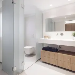 Baños modernos con ducha, inodoro y lavabo con mueble de madera.