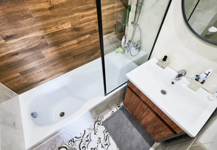 Baño moderno con ducha y bañera. Aprende como quitar una mampara pegada con silicona para renovar tu espacio.