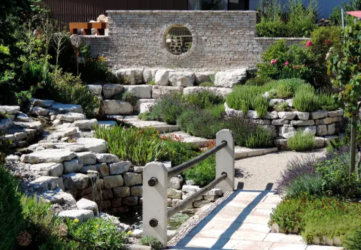 Un hermoso jardín con cascadas de piedra y plantas aromáticas, ideal para decorar jardín con piedras y crear un oasis de paz.