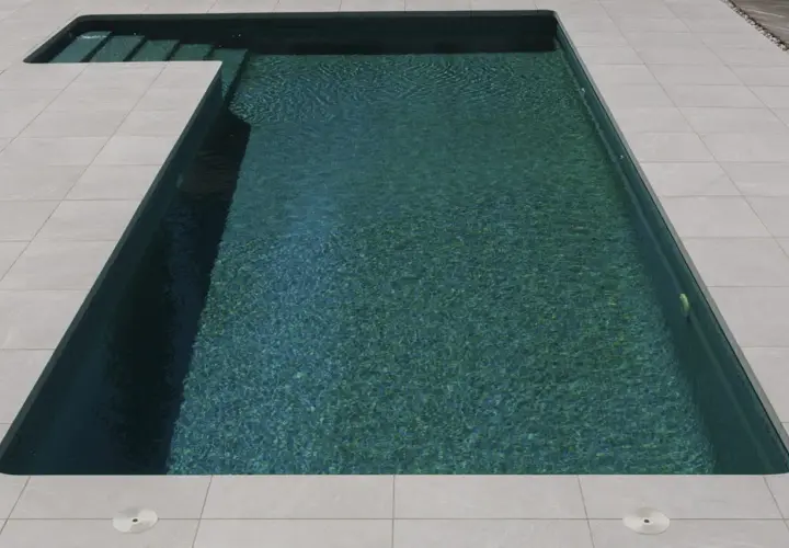 Bordes de piscinas modernas con escalones integrados y un revestimiento de baldosas claras que contrastan con el agua turquesa.