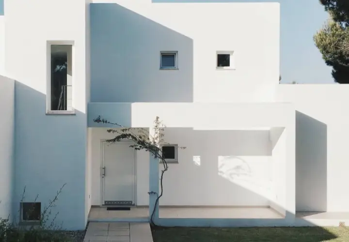 Fachada blanca moderna con sombras marcadas. La mejor pintura para fachadas exteriores protege y embellece esta arquitectura minimalista.