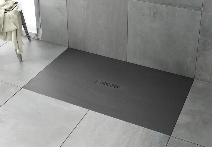 Plato de ducha moderno de pizarra gris con desagüe central. Ideal para limpiar y mantener tu baño impecable.