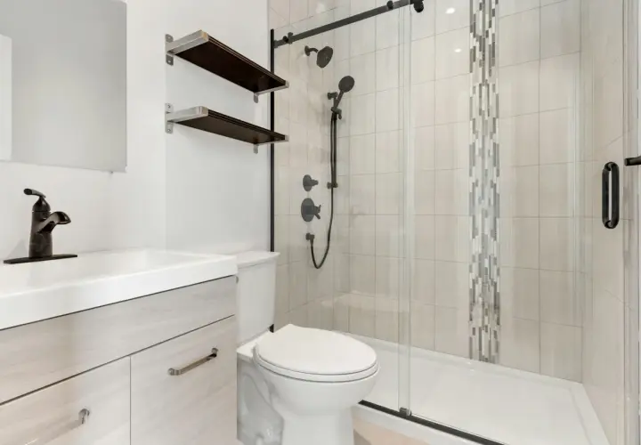 Baño moderno con lavabo, inodoro y plato de ducha de resina. Ideal para aprender como reparar un plato de ducha de resina.