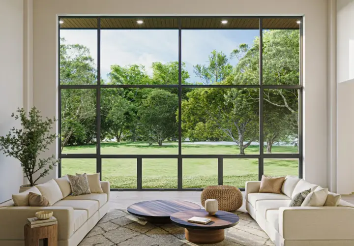 Salón moderno con sofás blancos y chimenea, enmarcado por amplias paredes de cristal que ofrecen vistas a un exuberante jardín verde.
