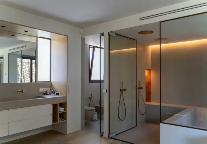 Baño moderno con ducha de cristal, bañera y ventana de cristal.