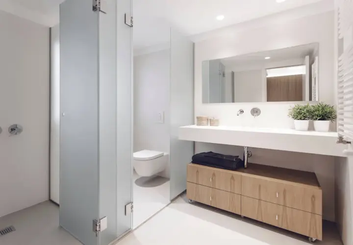 Baños modernos con ducha, inodoro y lavabo con mueble de madera.