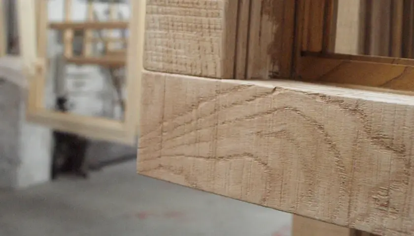 Marco de ventana de madera con vetas visibles y detalle de textura.