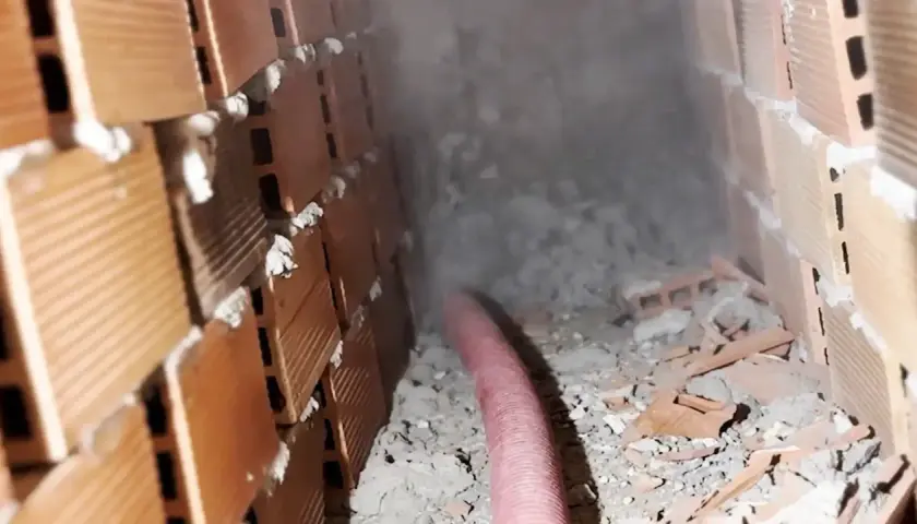 Proceso de aislamiento para como aislar un techo del calor, con material espumoso inyectado en cavidades de ladrillo.