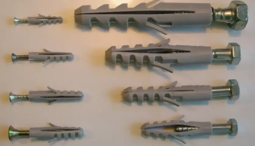 Variedad de tipos de tacos para pared, con tornillos de diferentes tamaños.