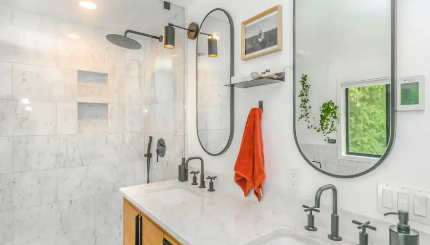 Baño moderno con ducha empotrada, lavabos dobles y grifería negra. Ideal para instalar grifo ducha empotrado.
