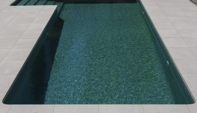 Bordes de piscinas modernas con escalones integrados y un revestimiento de baldosas claras que contrastan con el agua turquesa.