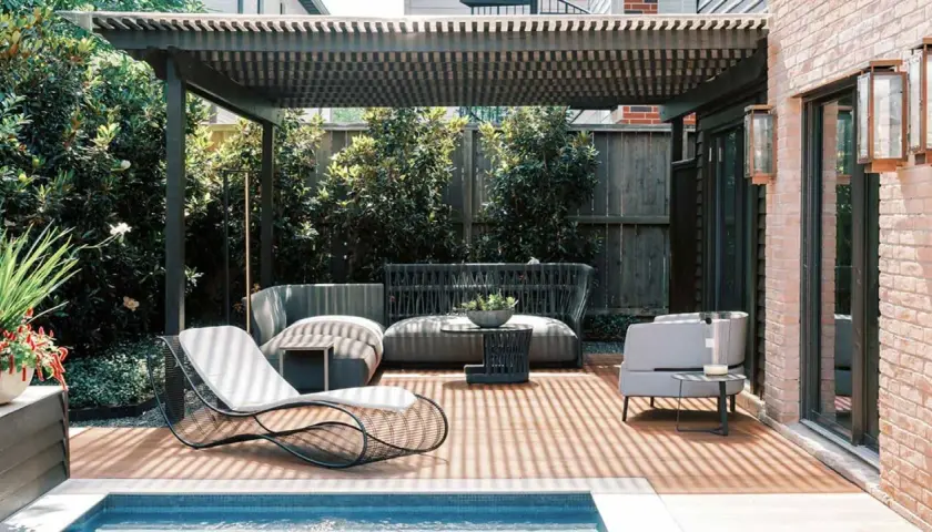 Modernos porches para patios con muebles de exterior, piscina y vegetación exuberante.