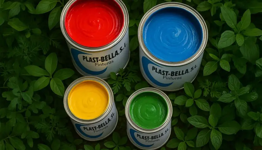 Latas de pintura para plástico de colores vibrantes: rojo, azul, amarillo y verde, rodeadas de hojas verdes.