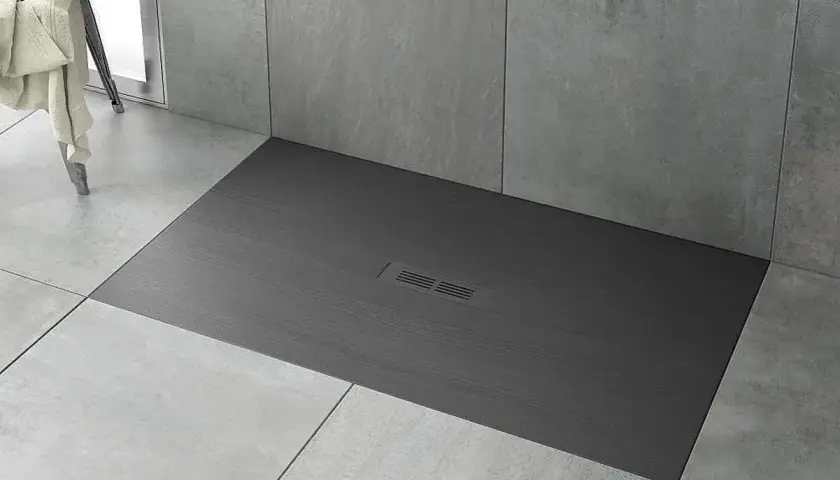 Plato de ducha moderno de pizarra gris con desagüe central. Ideal para limpiar y mantener tu baño impecable.
