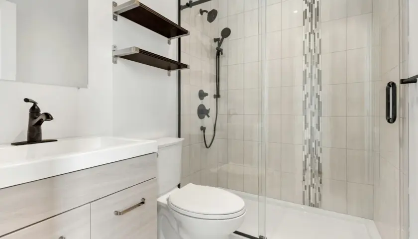 Baño moderno con lavabo, inodoro y plato de ducha de resina. Ideal para aprender como reparar un plato de ducha de resina.