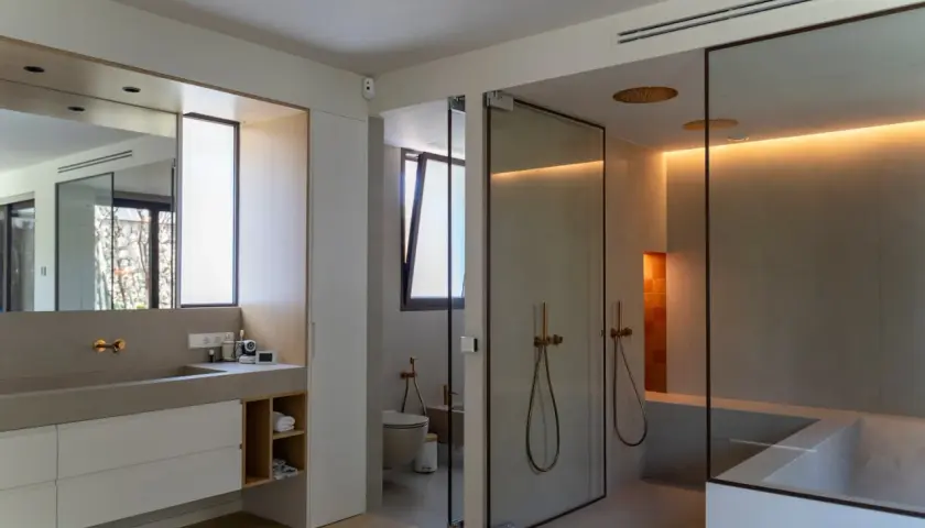 Baño moderno con ducha de cristal, bañera y ventana de cristal.
