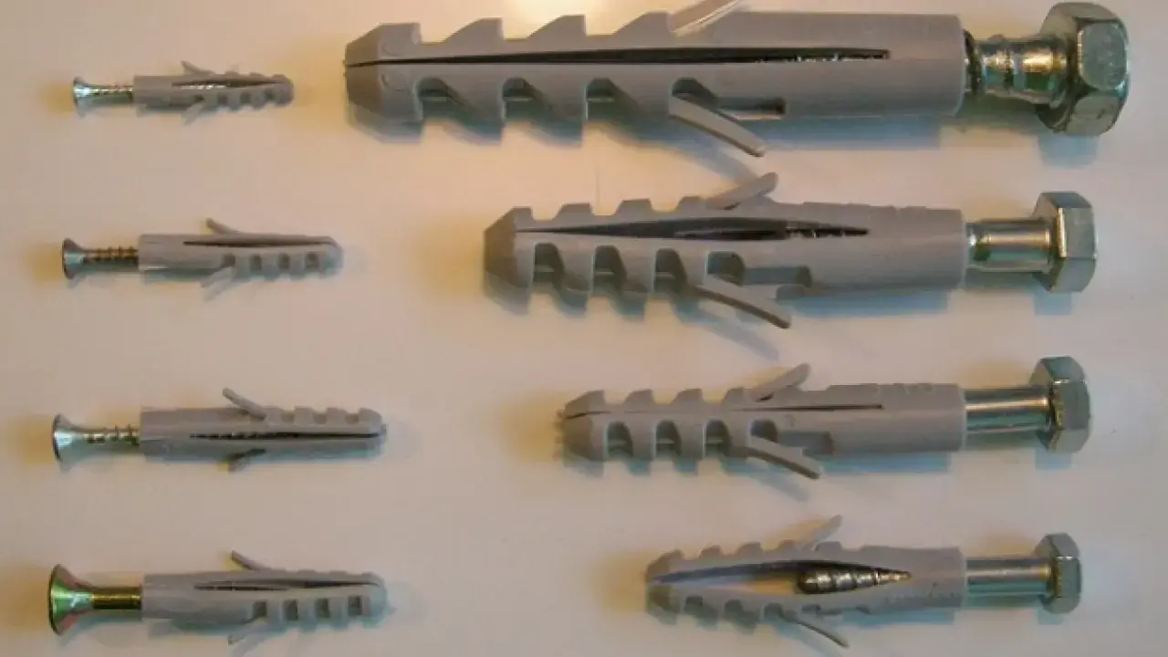 Variedad de tipos de tacos para pared, con tornillos de diferentes tamaños.