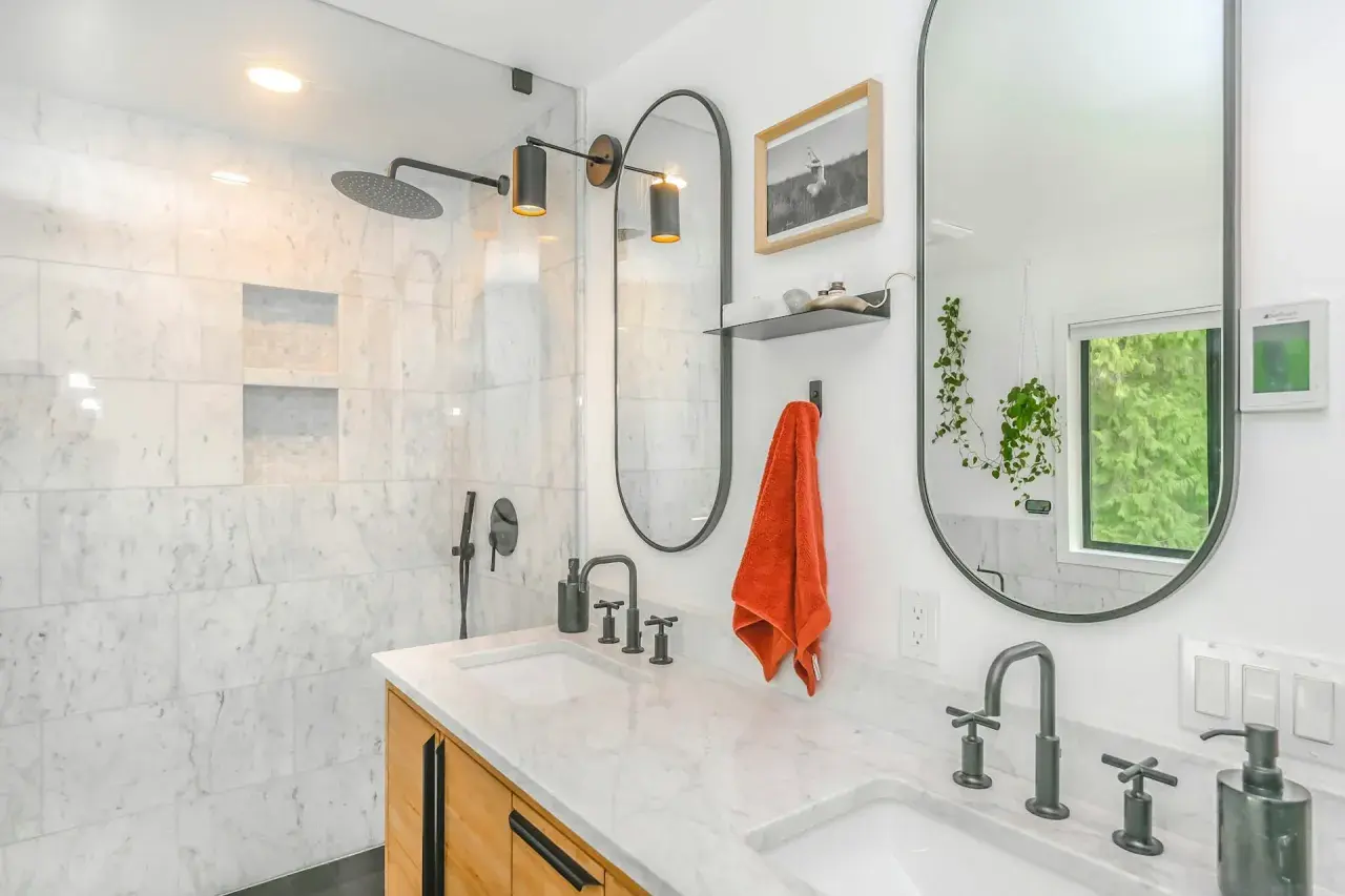 Baño moderno con ducha empotrada, lavabos dobles y grifería negra. Ideal para instalar grifo ducha empotrado.