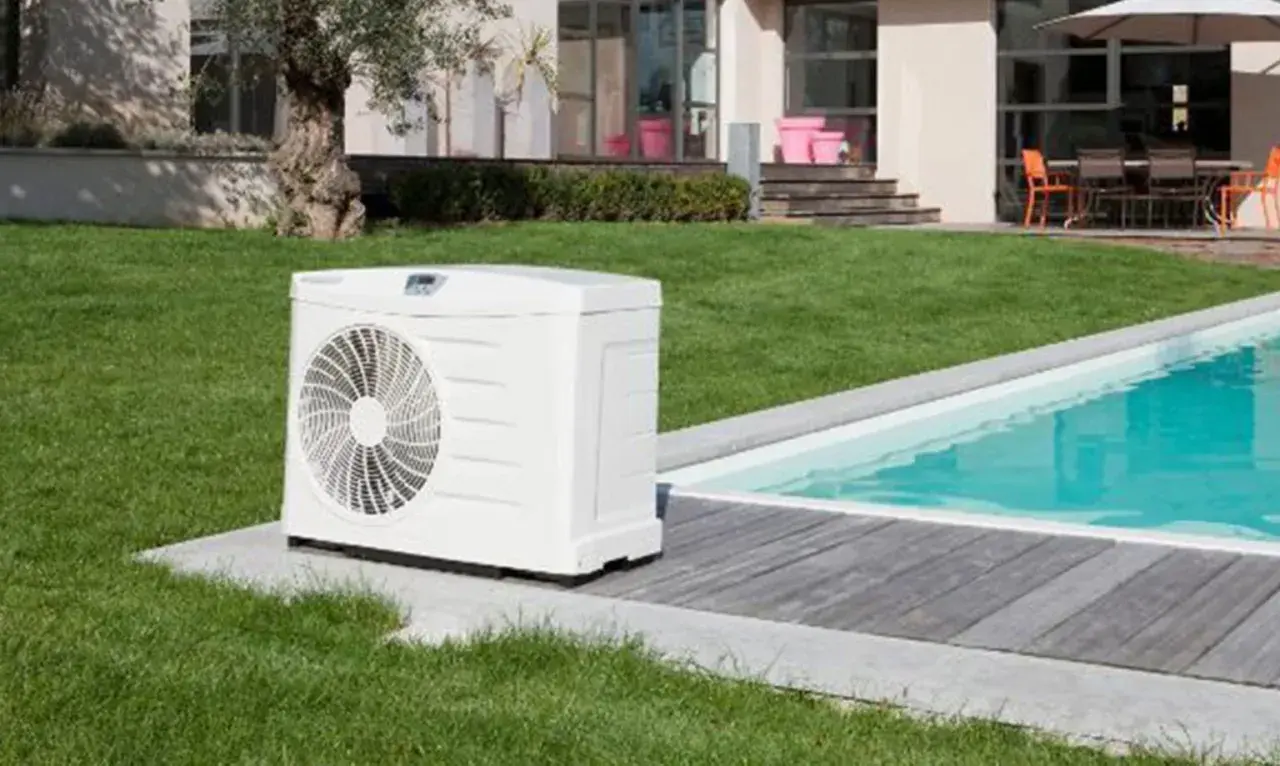 Bomba de calor junto a una piscina, ideal para saber como calentar el agua de la piscina y disfrutarla todo el año.