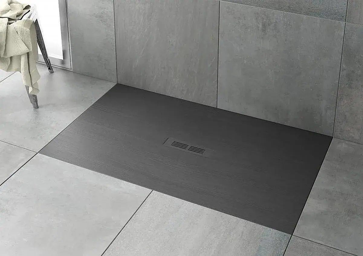 Plato de ducha moderno de pizarra gris con desagüe central. Ideal para limpiar y mantener tu baño impecable.