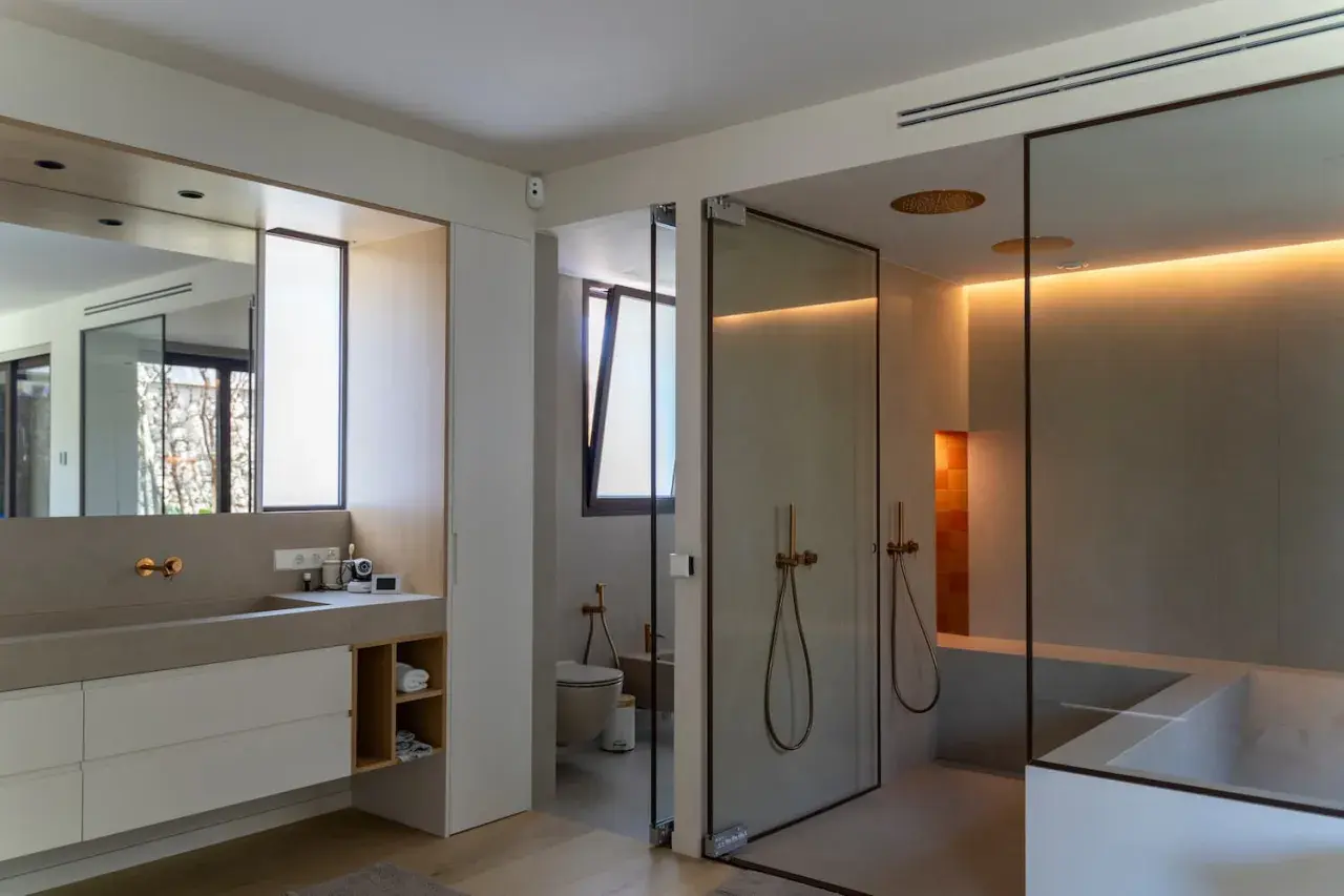 Baño moderno con ducha de cristal, bañera y ventana de cristal.