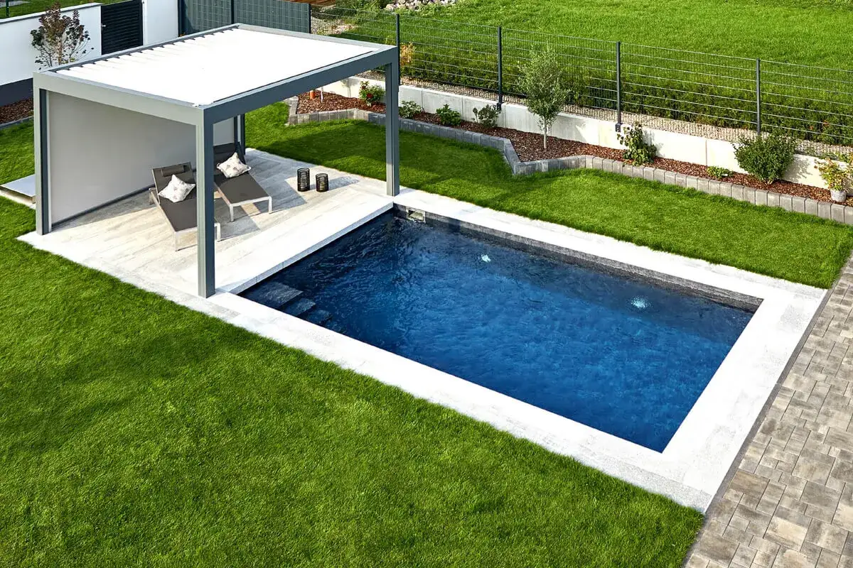 Piscina de obra peque&ntilde;a con tumbonas bajo p&eacute;rgola. Ideal para aprender como hacer una piscina de obra peque&ntilde;a y disfrutar del verano.