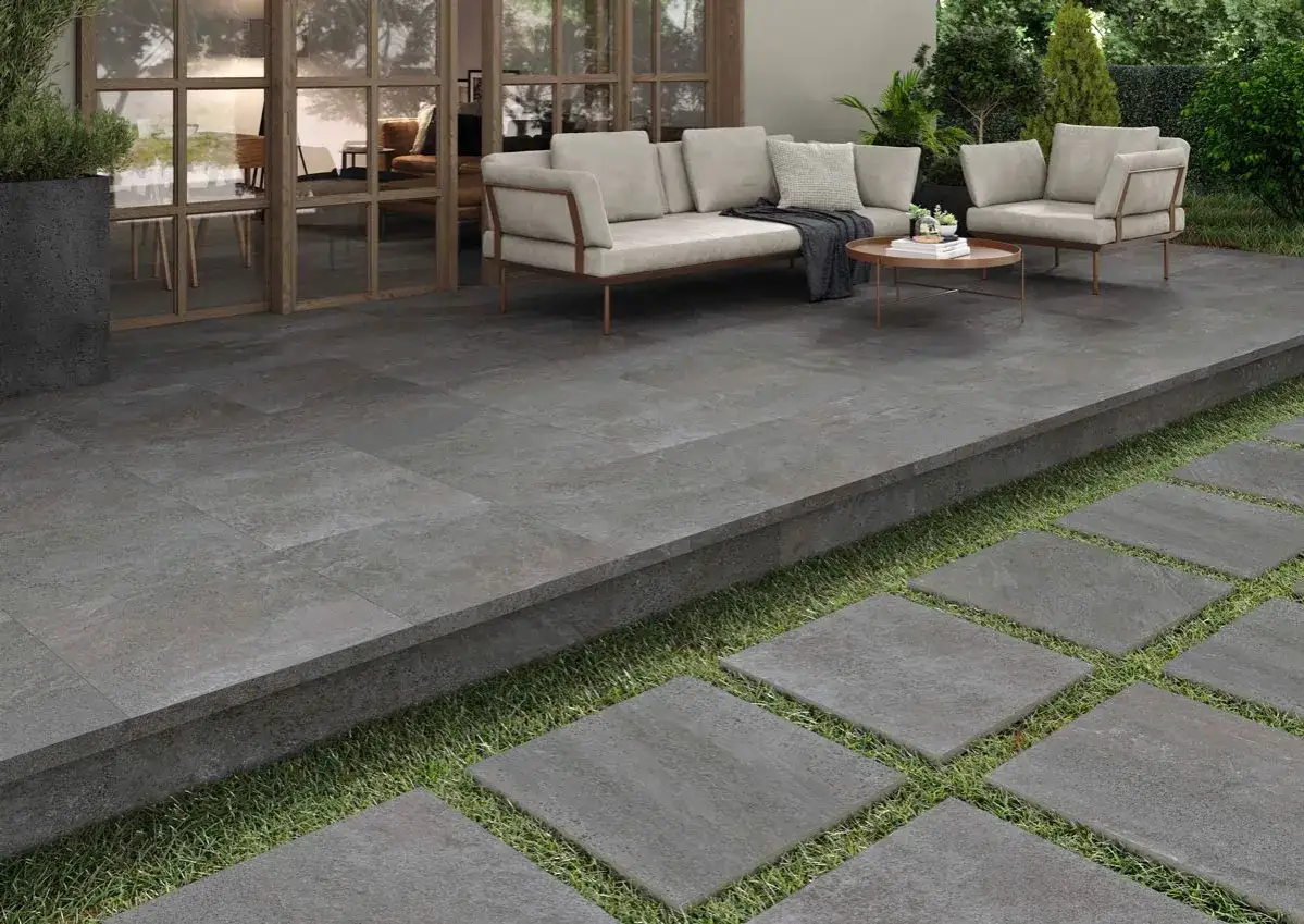 Modern patio with grey stone tiles, perfect for suelos para jardin sin obra. Comfortable seating area and garden access.