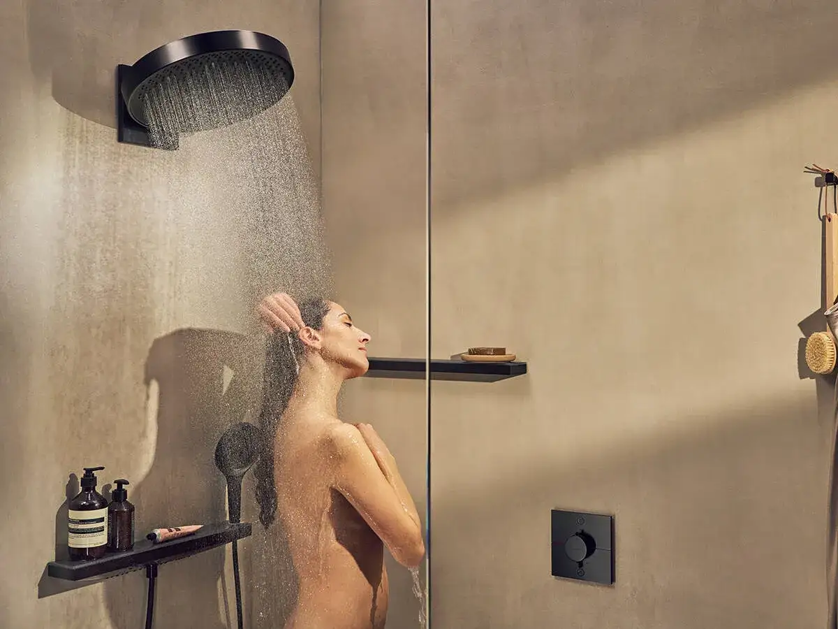 Mujer disfrutando de una ducha con un moderno grifo de ducha empotrado. El dise&ntilde;o minimalista y elegante resalta la facilidad de instalar grifo ducha empotrado.