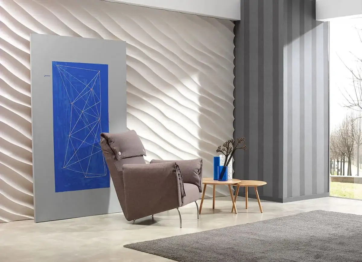 Un sill&oacute;n c&oacute;modo junto a una pared con relieve, ideal para insonorizar pared sin obra. Arte moderno y decoraci&oacute;n elegante.