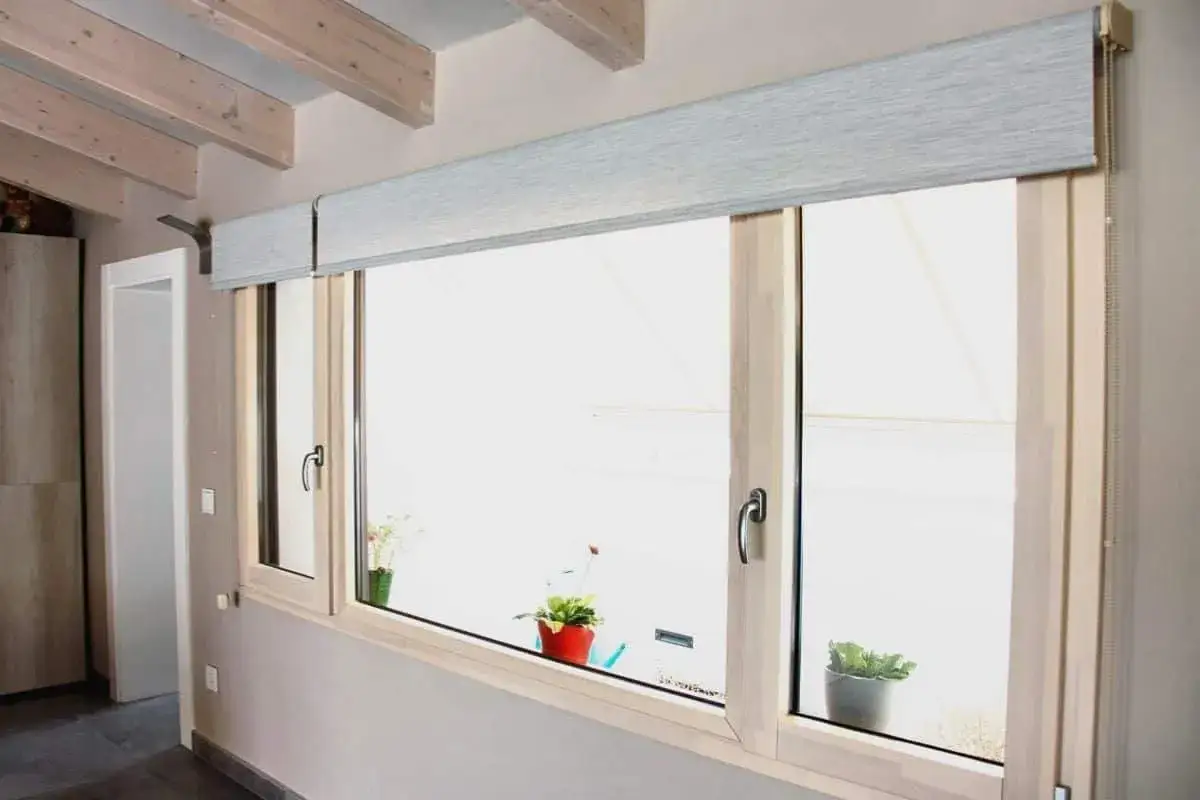 Ventana con estor enrollable de tela gris. Aprende como hacer un estor enrollable de tela para decorar tu hogar.