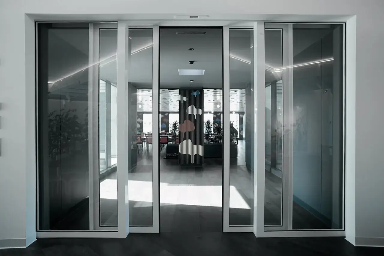 Modern interior con varios tipos de ventanas correderas de cristal, creando un espacio luminoso y abierto.